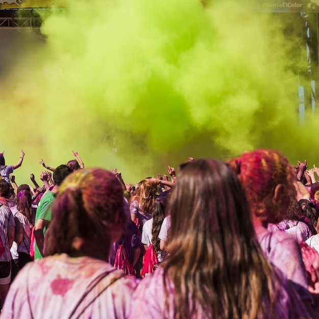 Foto gratuita dos amigas mirando a la gente bailando en la explosión de color holi