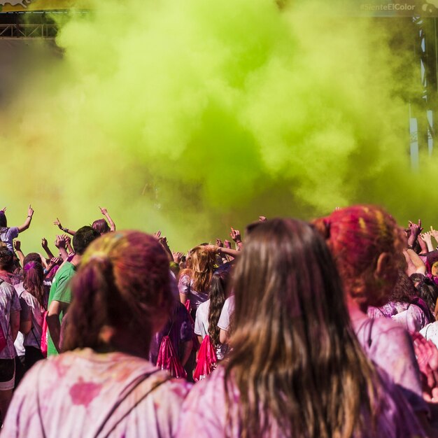 Dos amigas mirando a la gente bailando en la explosión de color holi