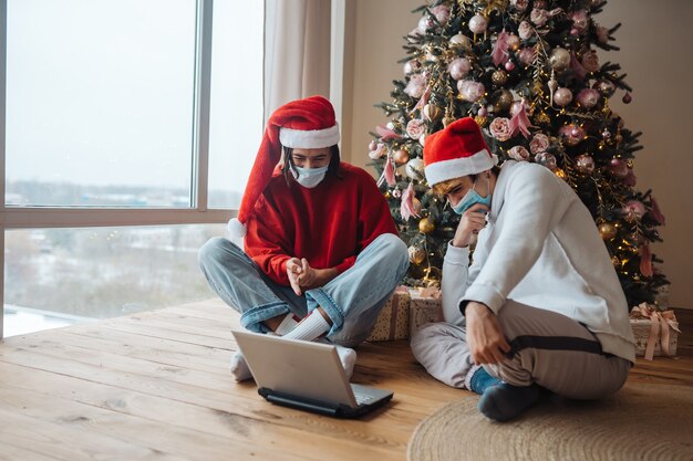 Dos amigos cerca de la computadora portátil están interactuando a través de videollamadas.