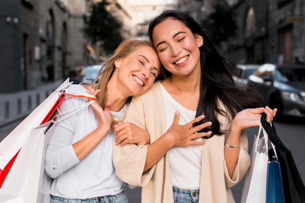 Foto gratuita dos amigos en la ciudad disfrutando de una juerga de compras