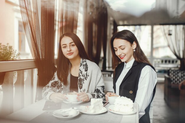 Dos amigos están tomando café en la cafetería.