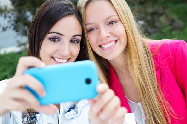 Dos amigos tomando fotos con un teléfono inteligente