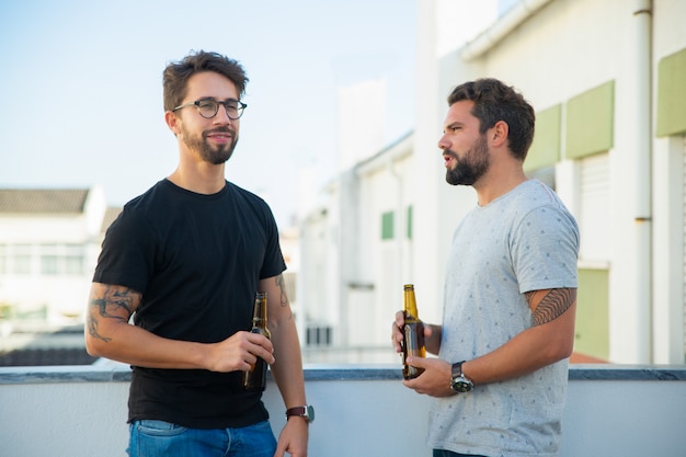 Dos amigos varones bebiendo cerveza y hablando