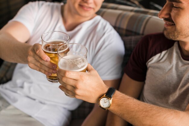 Dos amigos varones tostando vidrio alcohólico