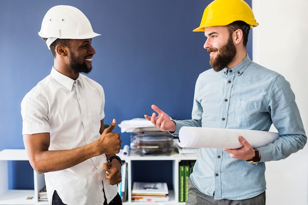 Dos arquitectos hombres exitosos conversan en la oficina