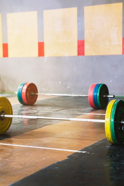 Foto gratuita dos barras de pesas en gimnasio