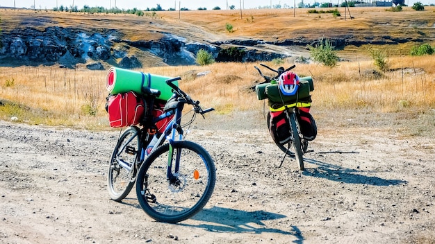 Dos bicicletas estacionadas con cosas del viajero en una carretera, barranco y campos en Moldavia