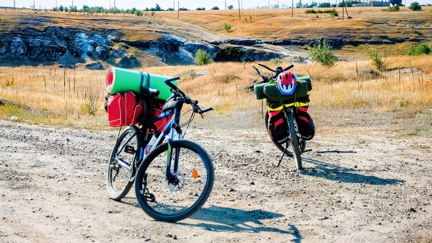 Dos bicicletas estacionadas con cosas del viajero en una carretera, barranco y campos en Moldavia