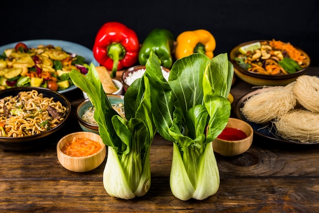 Dos bokchoy frente a la deliciosa comida tailandesa en el escritorio