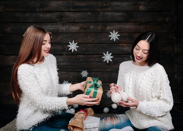 Dos bonitas mujeres posando con regalos para Navidad