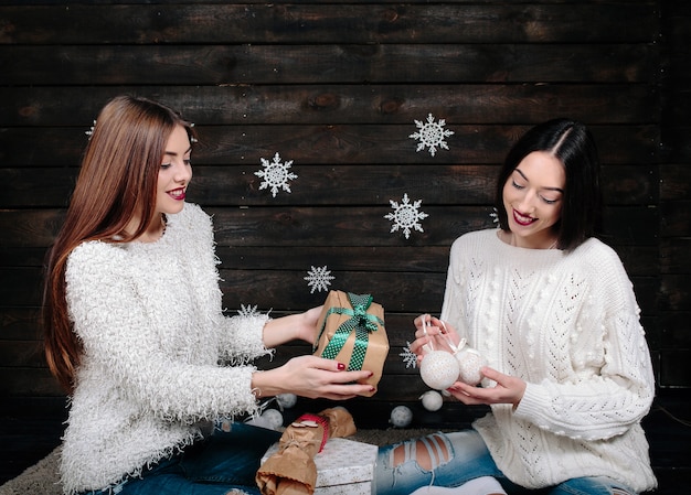 Dos bonitas mujeres posando con regalos para Navidad