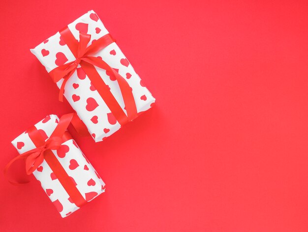 Dos cajas de regalo en mesa roja