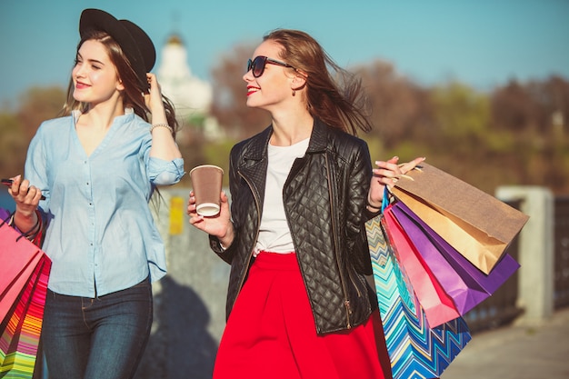 Foto gratuita dos chicas caminando de compras por las calles de la ciudad.