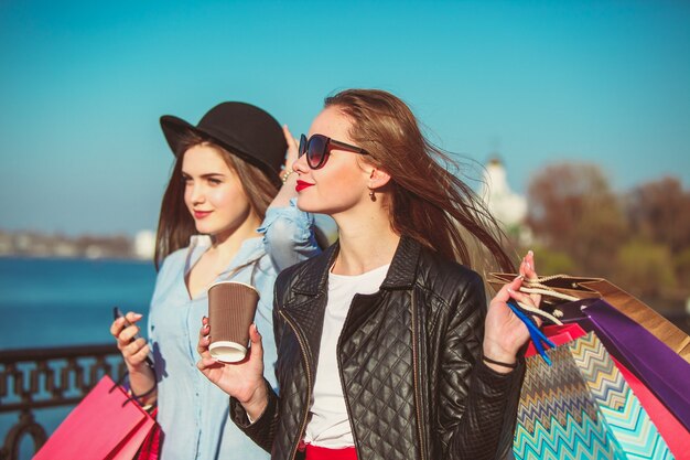 Dos chicas caminando con compras en las calles de la ciudad.