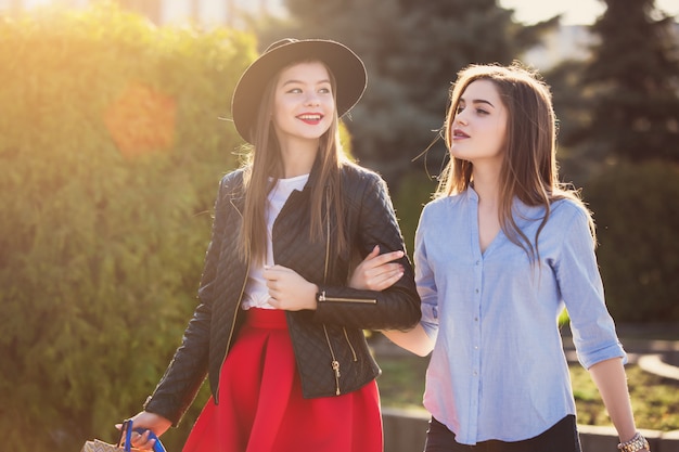 Dos chicas caminando con compras en calles de la ciudad