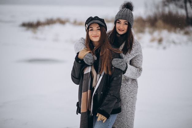 Dos chicas caminando juntas en un parque de invierno