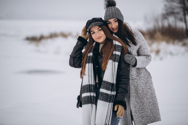 Dos chicas caminando juntas en un parque de invierno