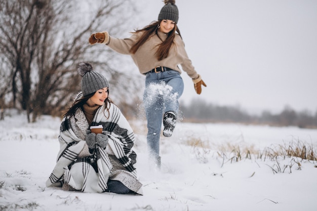 Dos chicas caminando juntas en un parque de invierno