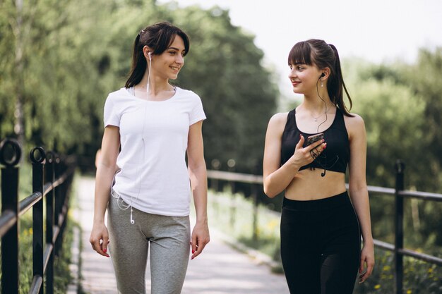Dos chicas caminando en el parque después de hacer ejercicio