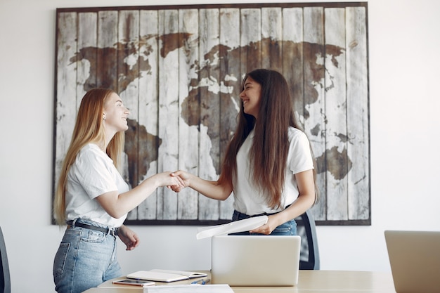 Foto gratuita dos chicas con una camiseta blanca trabajando en la oficina