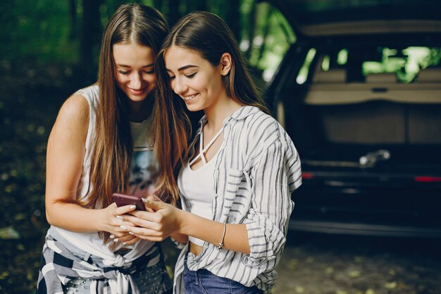 Foto gratuita dos chicas cerca de coche