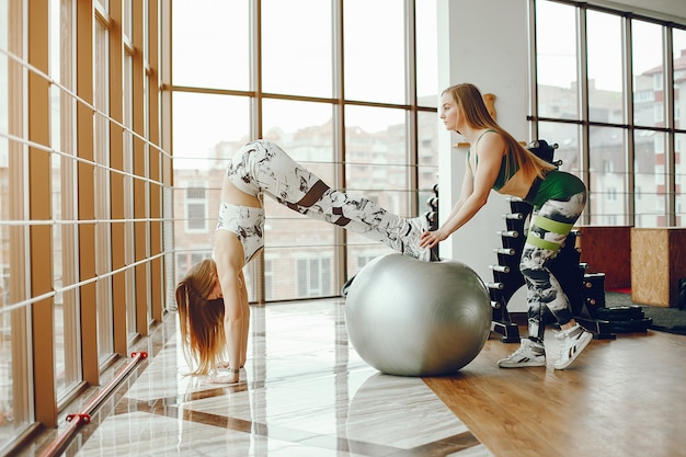 Foto gratuita dos chicas deportivas en un gimnasio