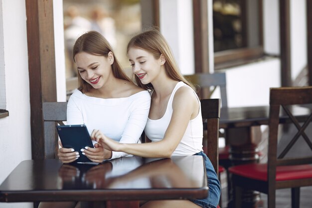 Dos chicas elegantes y con estilo en un café de verano.