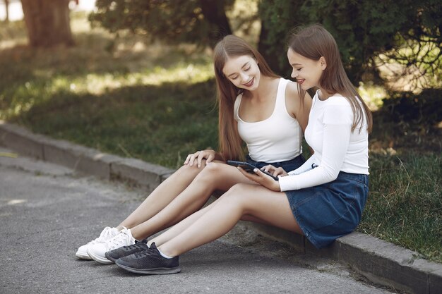 Dos chicas elegantes y con estilo en un parque de primavera