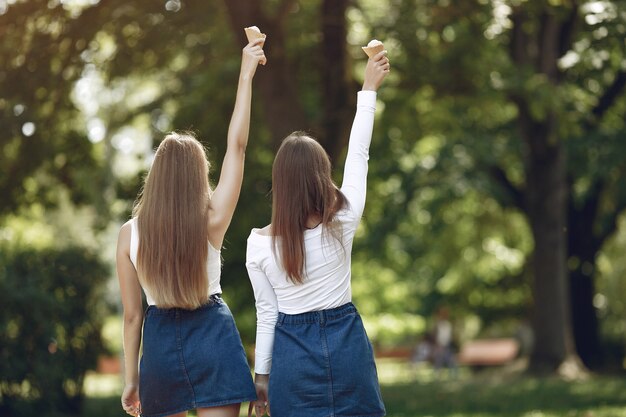 Dos chicas elegantes y con estilo en un parque de primavera