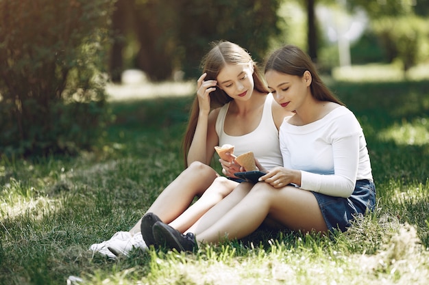 Dos chicas elegantes y con estilo en un parque de primavera