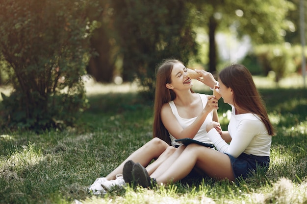 Dos chicas elegantes y con estilo en un parque de primavera