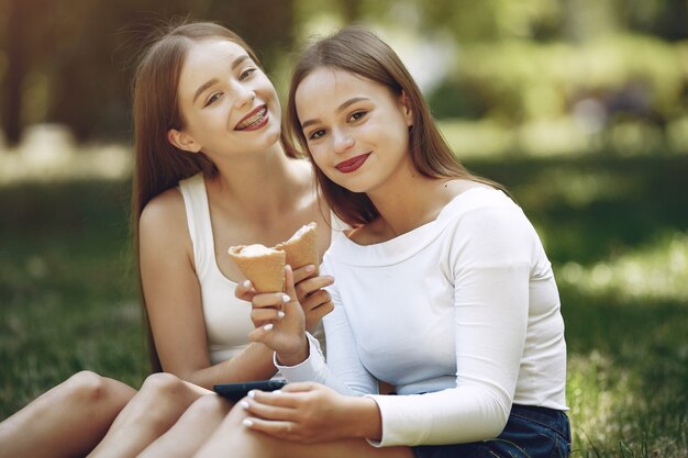 Dos chicas elegantes y con estilo en un parque de primavera