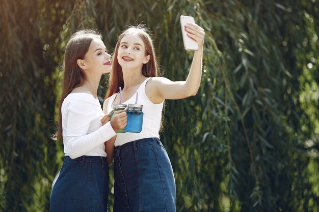 Dos chicas elegantes y con estilo en un parque de primavera