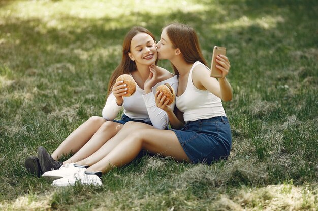 Dos chicas elegantes y con estilo en un parque de primavera