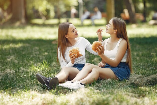 Dos chicas elegantes y con estilo en un parque de primavera