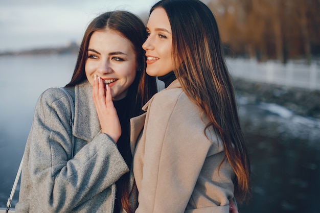 Dos chicas con estilo descansan en una ciudad.