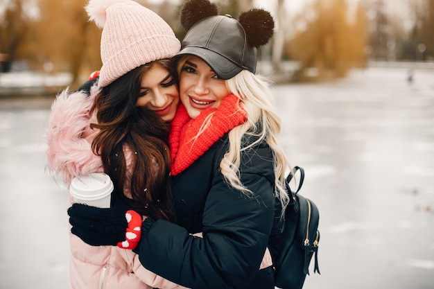 Dos chicas con estilo descansan en una ciudad.