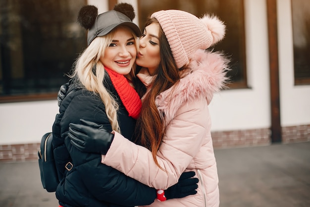 Dos chicas con estilo descansan en una ciudad.