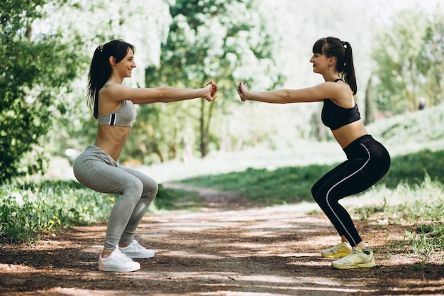 Dos chicas en forma que se extiende en el parque