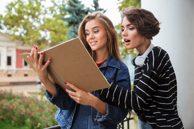 Dos chicas guapas adolescentes jóvenes estudiando juntos