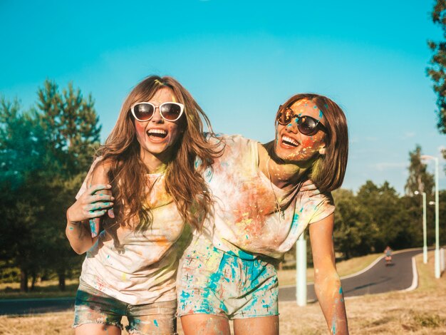 Dos chicas guapas felices haciendo fiesta en el festival de colores Holi