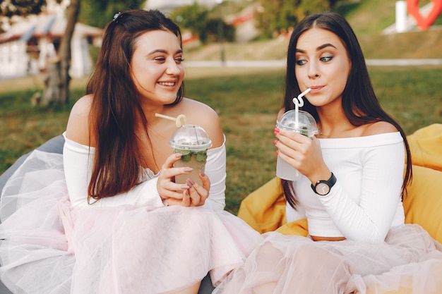 Foto gratuita dos chicas guapas en un parque de verano