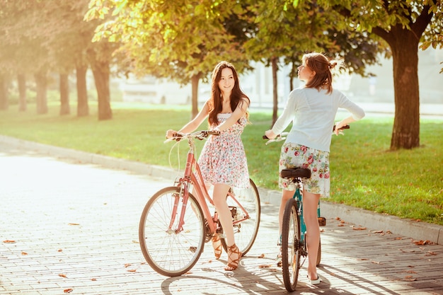 dos chicas jóvenes con bicicletas en el parque