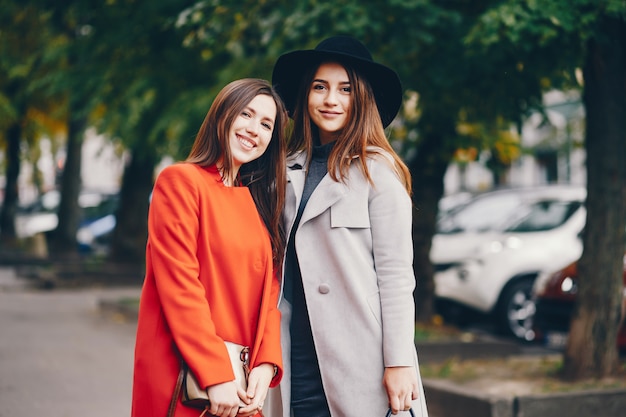 dos chicas jóvenes y bonitas caminando en una ciudad de otoño