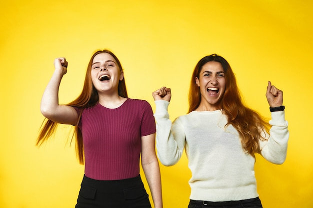 Dos chicas jóvenes se ven muy felices de pie