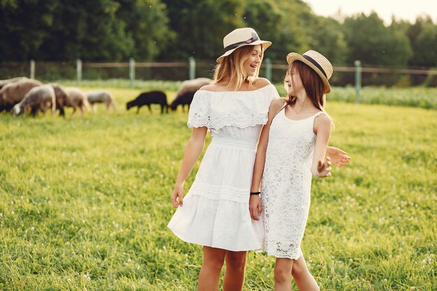 Dos chicas lindas en un campo con cabras