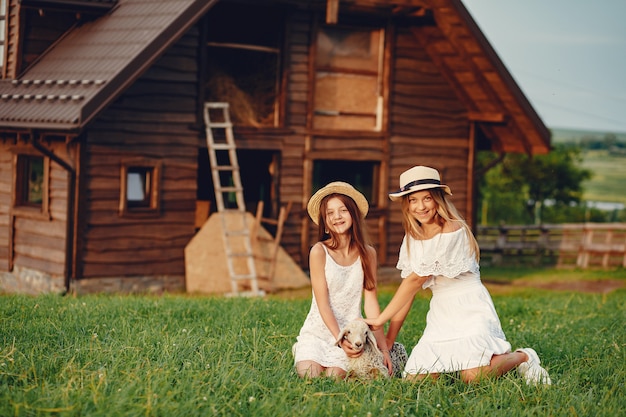 Dos chicas lindas en un campo con cabras