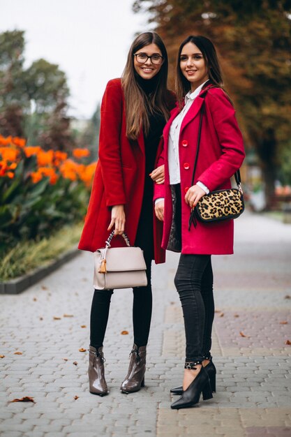 Dos chicas en modelos de abrigos rojos.