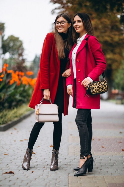 Dos chicas en modelos de abrigos rojos.