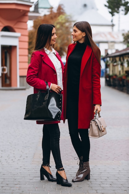 Dos chicas en modelos de abrigos rojos.